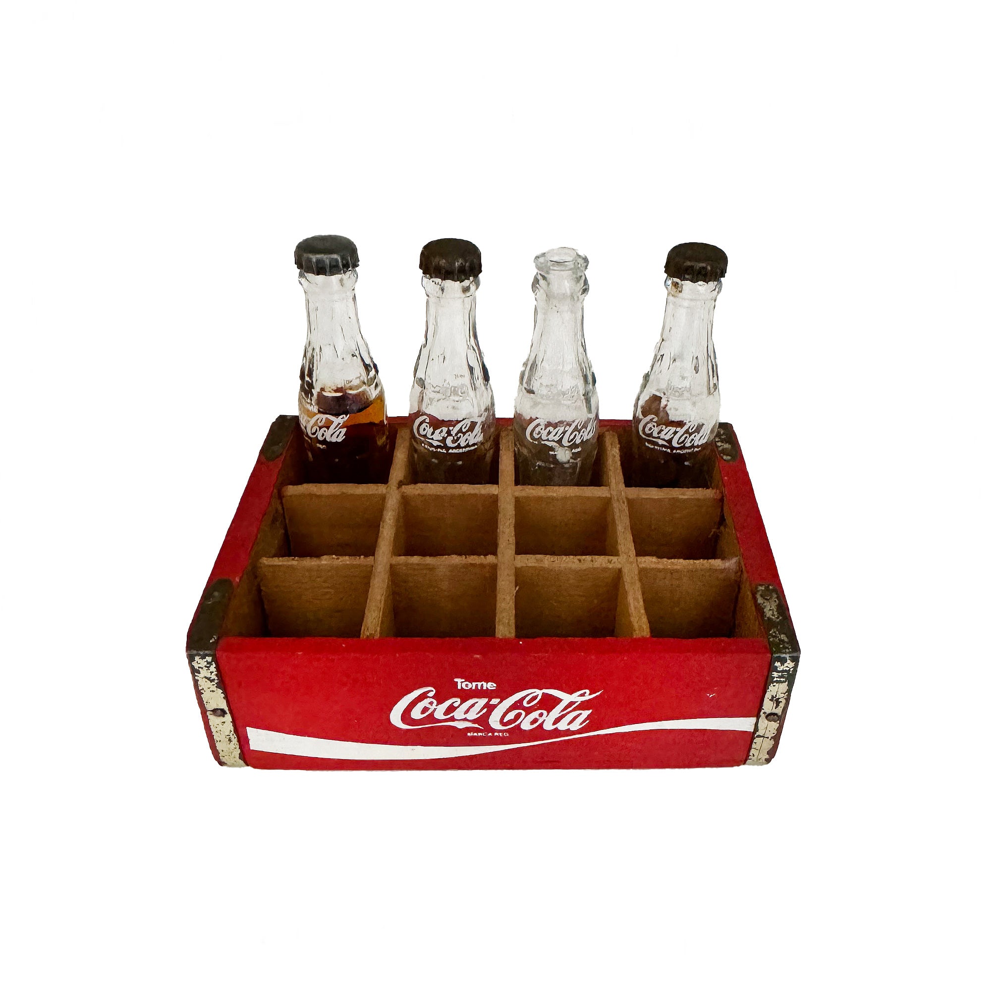 A vintage crate of 4 Coca Cola bottles in miniature one has contents 