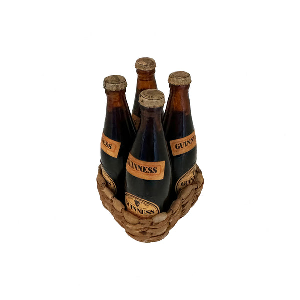 a basket with 4 miniature Guinness bottles inside