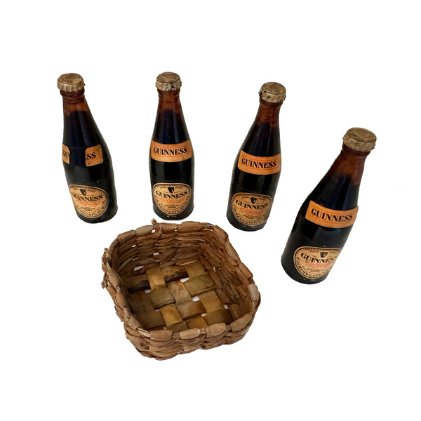 a set of miniature Guinness bottles with woven basket in miniature