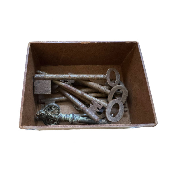 a set of various keys inside a cardboard box antique