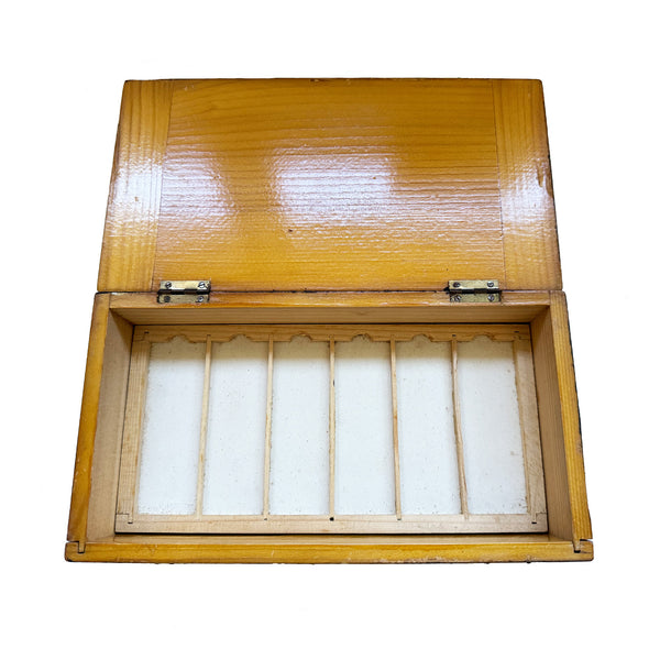 A wooden box of empty microscope slide trays