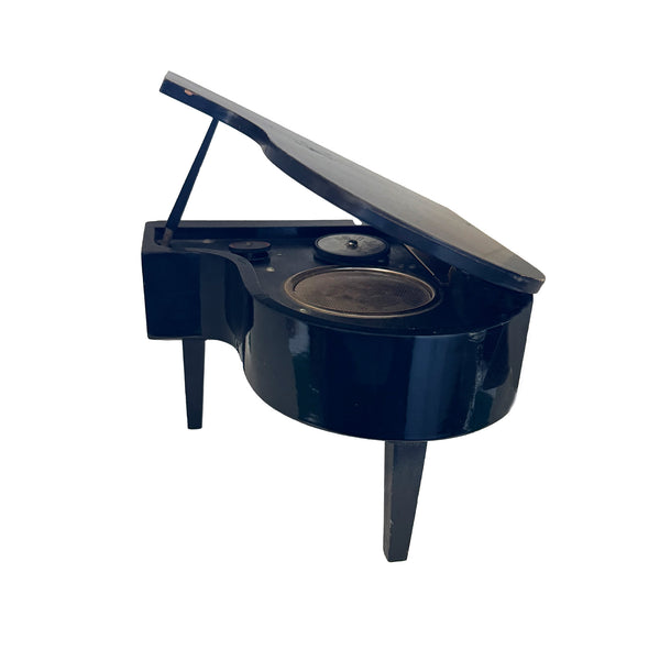 A vintage miniature grand piano in black with speaker and radio transmission