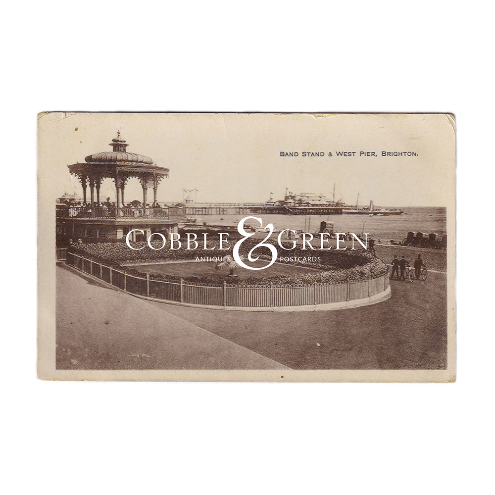 A sepia old postcard of the band stand and west pier in Brighton