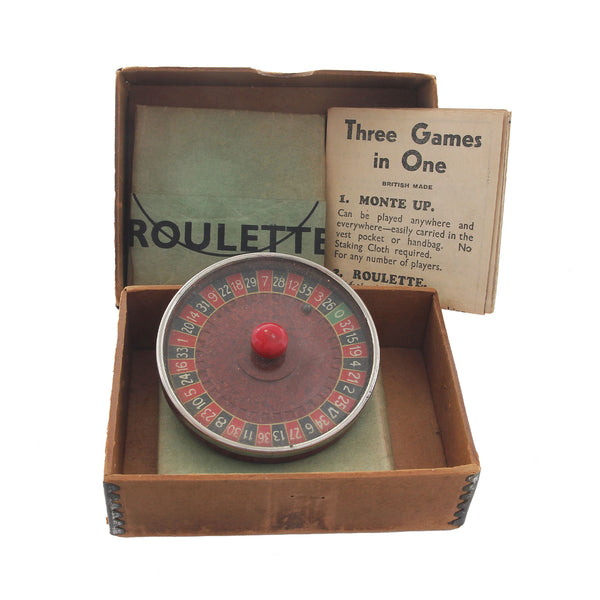 A miniature vintage roulette wheel with papers and original box