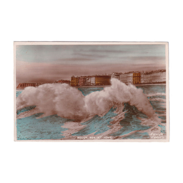 A colour real photo of the rough sea in Hove Brighton east sussex buildings in the background