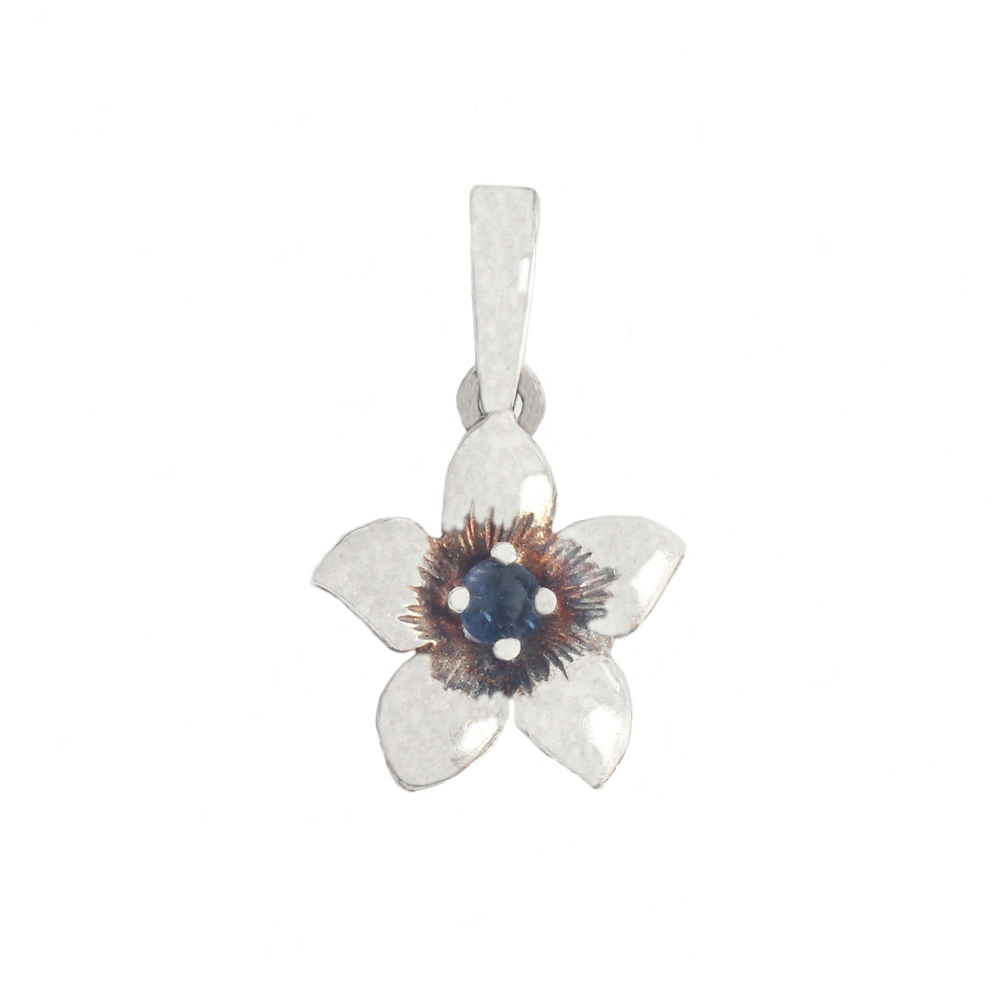 A silver vintage flower shaped pendant with a blue sapphire stone centre