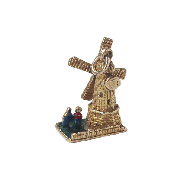 a secondhand yellow gold detailed windmill with moving sails and lady man enamel standing beside