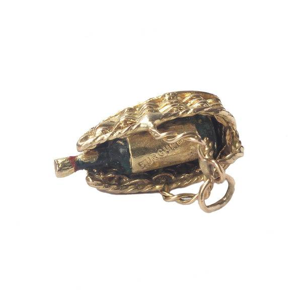 A vintage gold burgundy wine bottle charm in a wicker basket dated 1960