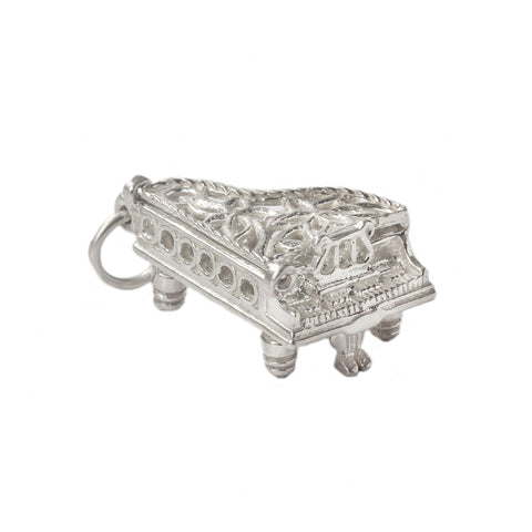 A vintage silver opening piano charm with musical notes inside