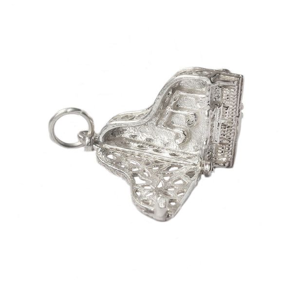 An opening silver piano charm with notes inside