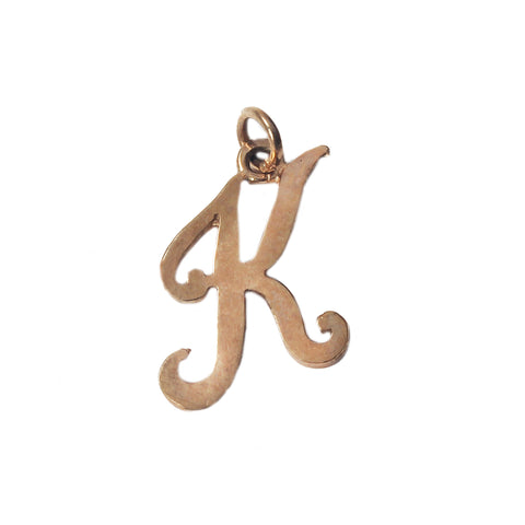 A plain scroll script initial K pendant in gold