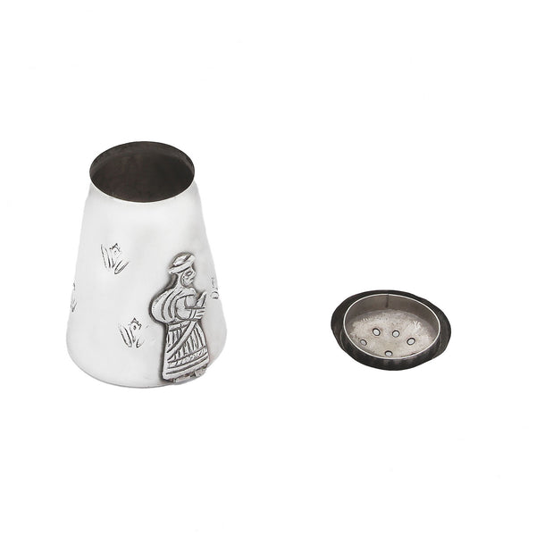 A vintage silver pepper with a gentleman standing and flowers on the side