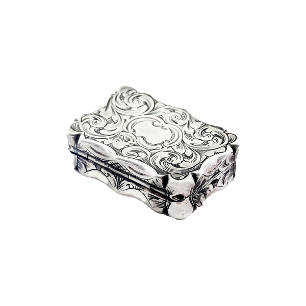 A floral scroll leaf silver vinaigrette with rounded sides dated 1854