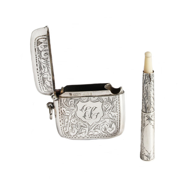 A sterling silver Edwardian vesta case and holder with initials and leaf pattern engraving dated 1906