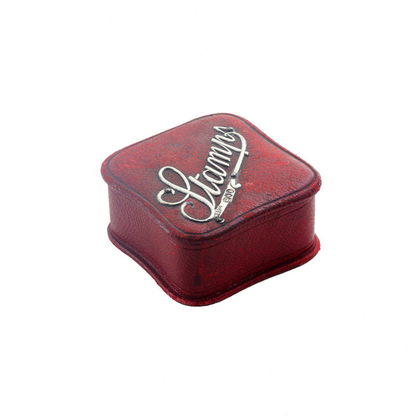 A stamp box with silver letters on top a red box dated 1901