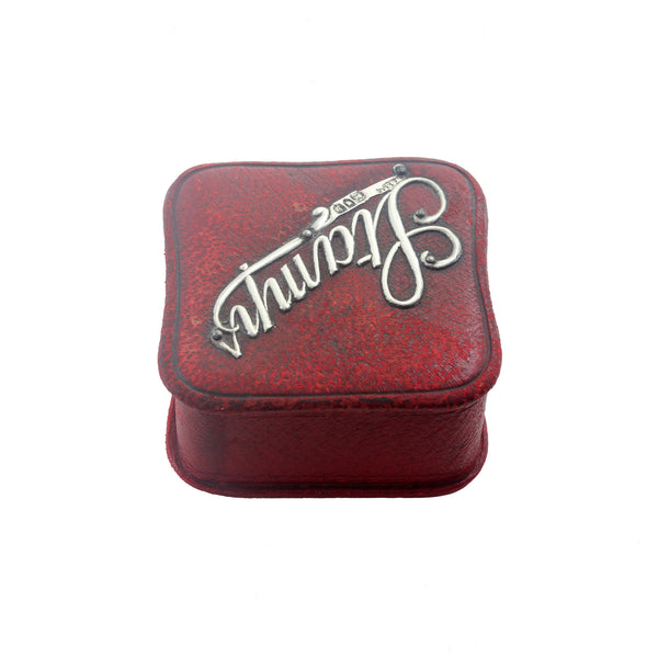 An antique red leather stamp box square with silver mounted letters on top