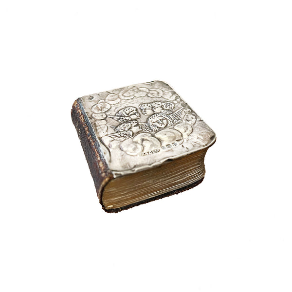 A preowned silver miniature prayer book hallmarked with cherubs dated 1904